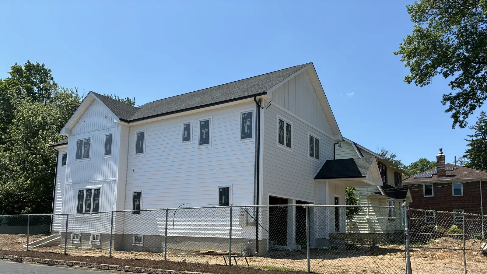 Two-story house with white board-and-batten siding after a GUS SKYY project